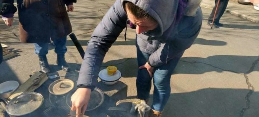 Alina Beskrovna cocina al aire libre en Mariupol tras la interrupción del suministro de gas y electricidad debido al conflicto.