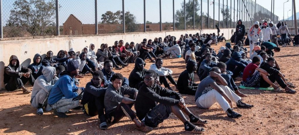 © UNICEF_Alessio Romenzi_3 Migrantes sentados en el patio de un centro de detención en Libia (imagen de archivo).