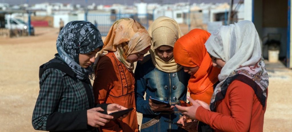 © UNICEF_UN051302_Herwig Adolescentes usando teléfonos celulares y tabletas digitales en el campamento de refugiados sirios de Za´atari. 