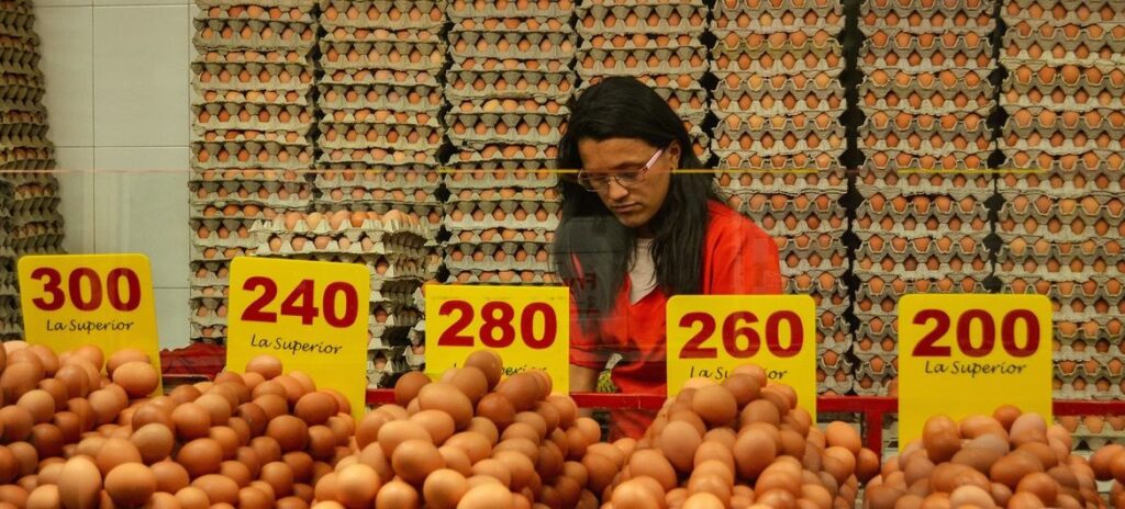Unsplash_Külli Kittus Una mujer vende huevos en una parada de mercado de alimentos en Medellín, Colombia.