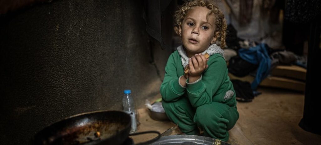 Imagen © OMS _3 Una niña en Gaza espera que le den algo de comer.