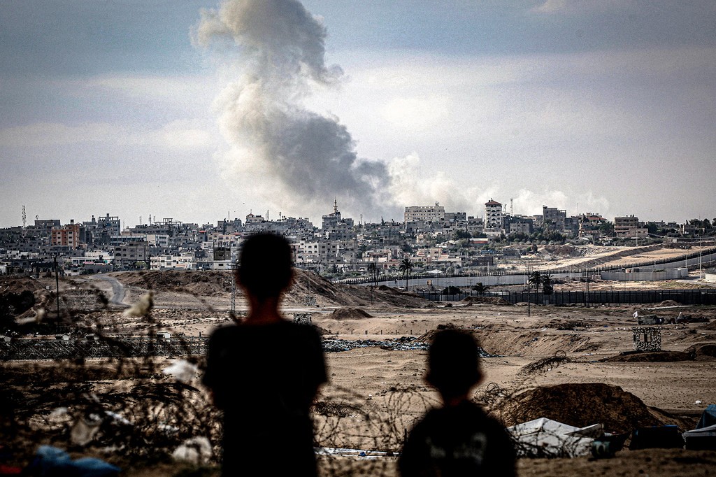 Imagen © UNICEF_2.jpg Dos niños observan columnas de humo tras un ataque aéreo sobre la ciudad de Gaza.