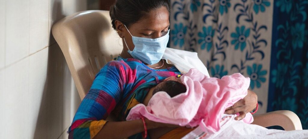 © UNICEF_Vinay Panjwani Una mujer amamanta a su bebé en una sala de parto en la India poco después de dar a luz.